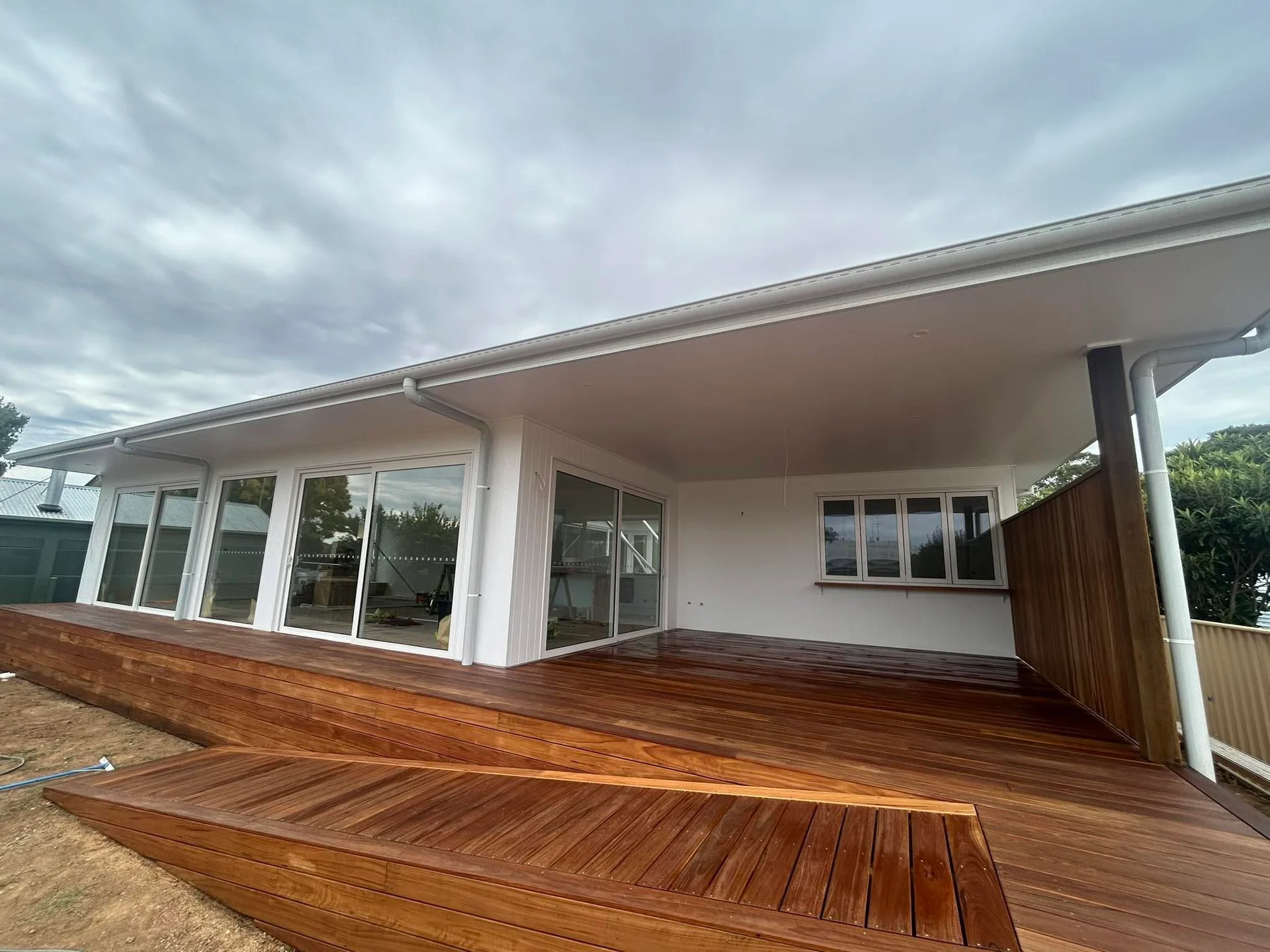 C & C Build Co’s completed white exterior opening onto a covered timber deck