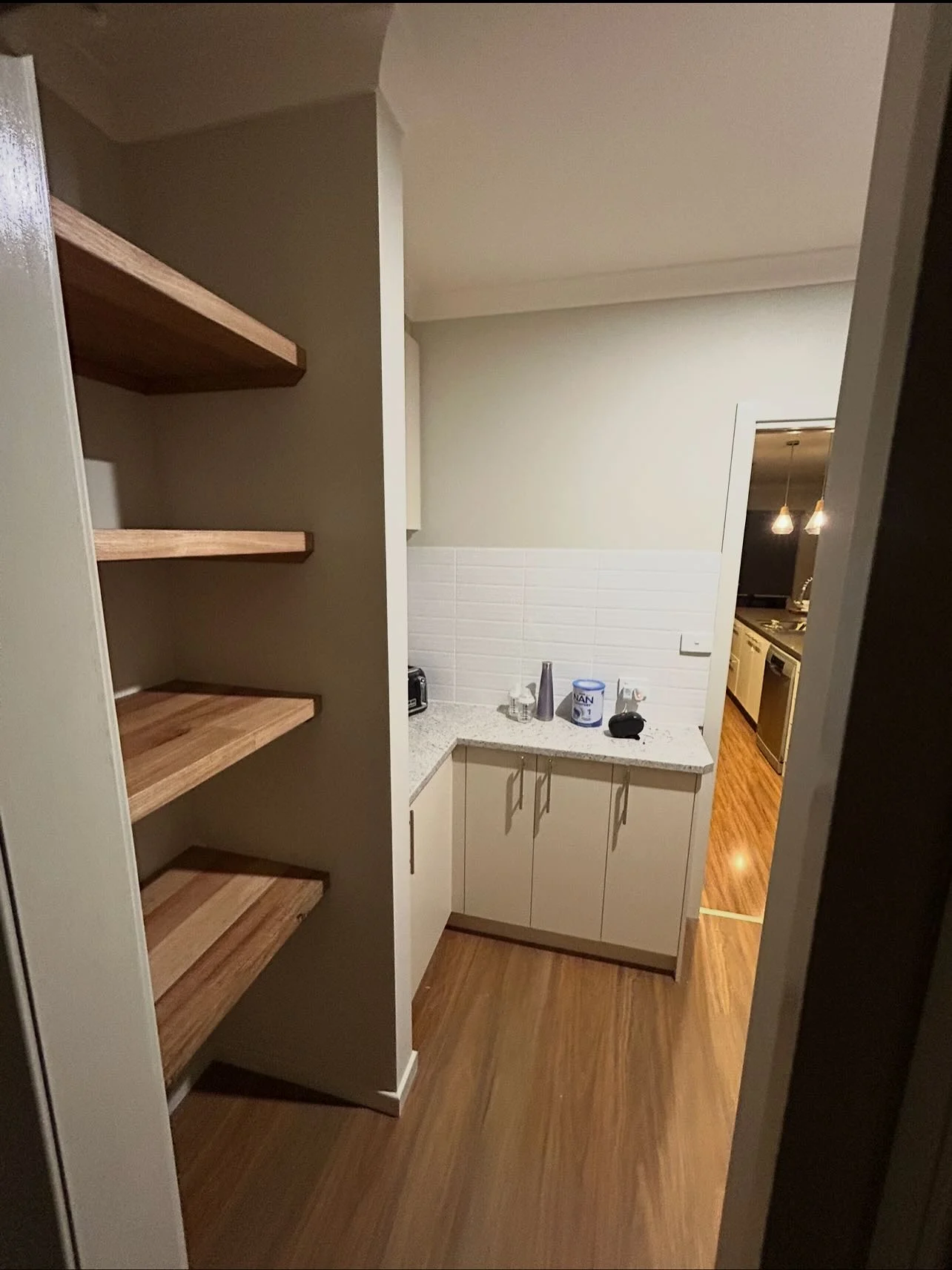Completed walk-through pantry with timber shelving